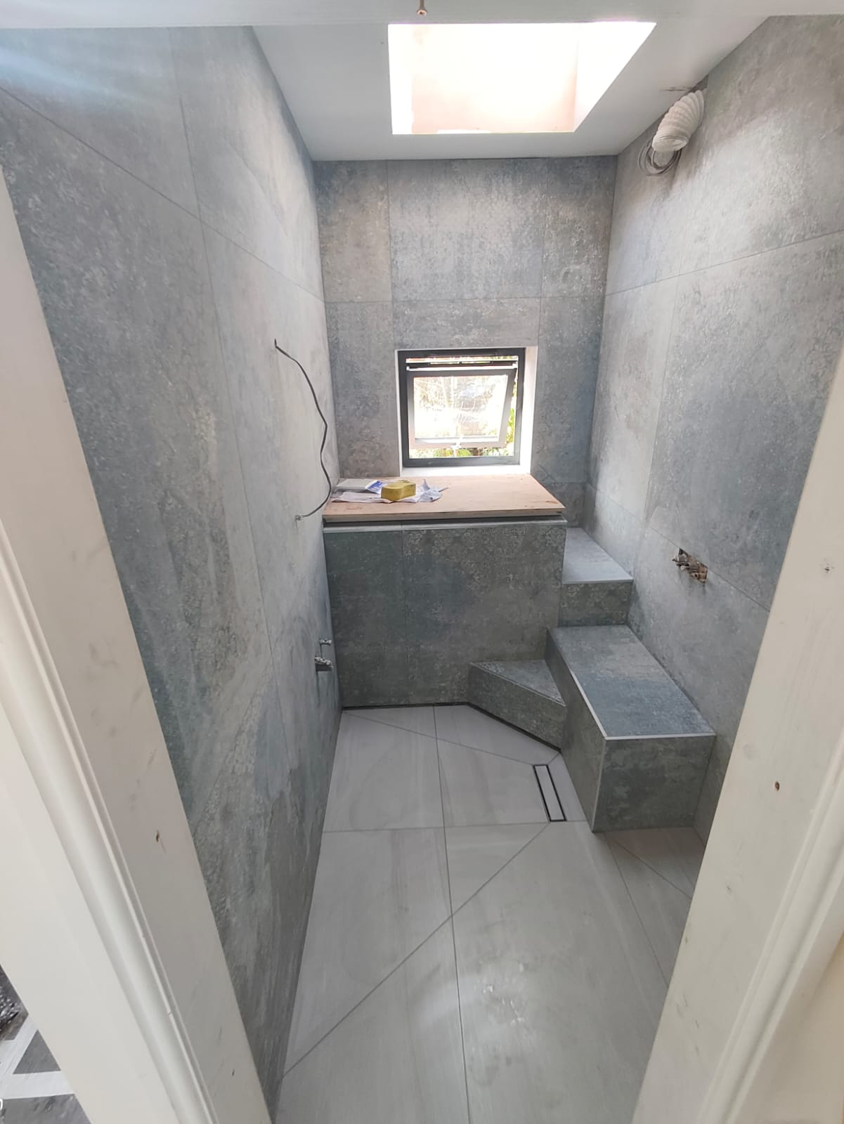 Łazienka w płytkach imitujących beton z zabudową